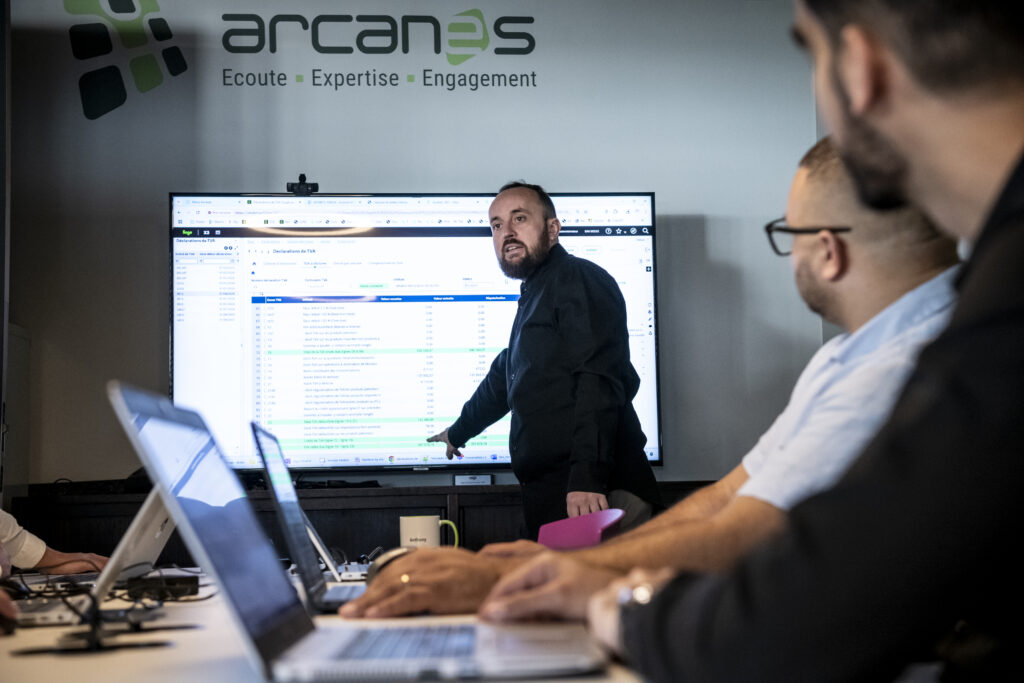 Photo d'une réunion entre collaborateurs, l'un présente le logiciel Sage X3 aux autres collaborateurs.